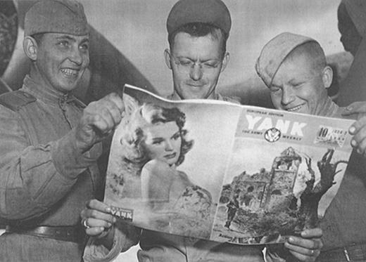 Cultural borrowing took off with the establishment of the Poltava air base. Here two Red Army soldiers and an American GI appreciate the articles in one of the magazines that circulated on and off the base. Courtesy National Archives, Washington, DC.