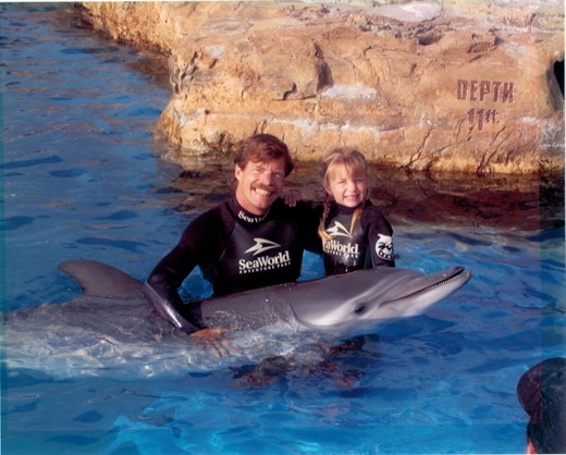 Kelsey and her father, Barney Barnhill, participating in a dolphin encounter at SeaWorld San Diego in 2000.