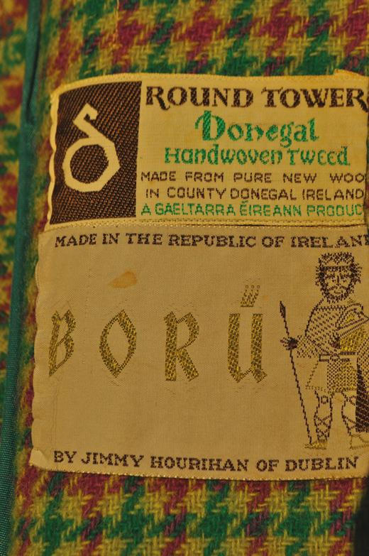 Jimmy Hourihan jacket label detail. The Hourihan label re-emphasizes the firm’s Dublin location and also names and depicts Brian Boru, an eleventh-century and Dublin-associated king whose defeat of the Norse later made him a nationalist icon. The ‘Gaeltarra Éireann’ detail on the fabric tag refers to an Irish government marketing project for crafts from Irish (Gaelic)-speaking districts such as Donegal, which was set up in 1957.