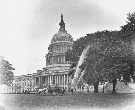 Unprotected workers with a horse-drawn tank sprayer treat tree pests in this East Front photograph of 1916.