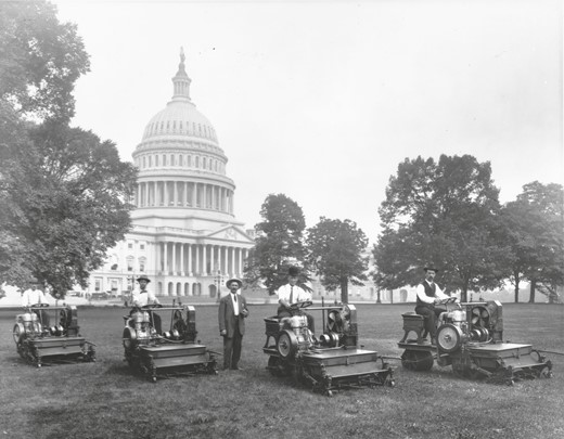 Architect of the Capitol landscape crew members pose beside gas-powered grass-cutting mowers in this 1910 photograph on the South Oval of the Capitol Square.