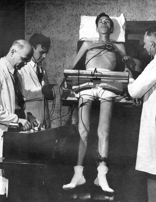 Life magazine photograph of conscientious objector being examined on a tilting table during starvation experiment. July 30,1945. Volume 19, Number 5, p. 45. Credit: Wallace Kirkland/Time Life Pictures/Getty Images.